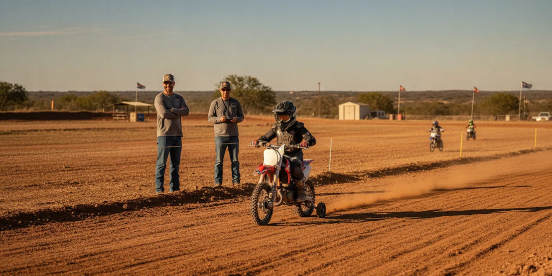 A beginner dirt bike rider practices on a broad, beginner-friendly motocross track